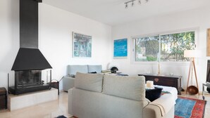 A modern living room with a fireplace, a sofa, a coffee table, and artwork on the walls. - Villa Bendinat 10: A luxurious oasis in Puerto Portals, Calvia (Calvià)