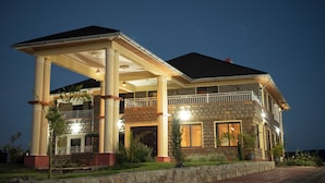 A two-story house with a covered porch, columns, and a brick exterior. - Mara Meguarra Sanctuary (Maasai Mara)