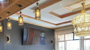 A modern interior with a central bar area, pendant lighting, and a large window providing natural light. - Mara Meguarra Sanctuary (Maasai Mara)