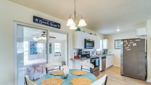 A kitchen with a dining table, chairs, a refrigerator, and a microwave. - 4 Mi to Beach: Charming Port Charlotte Home! (Port Charlotte)