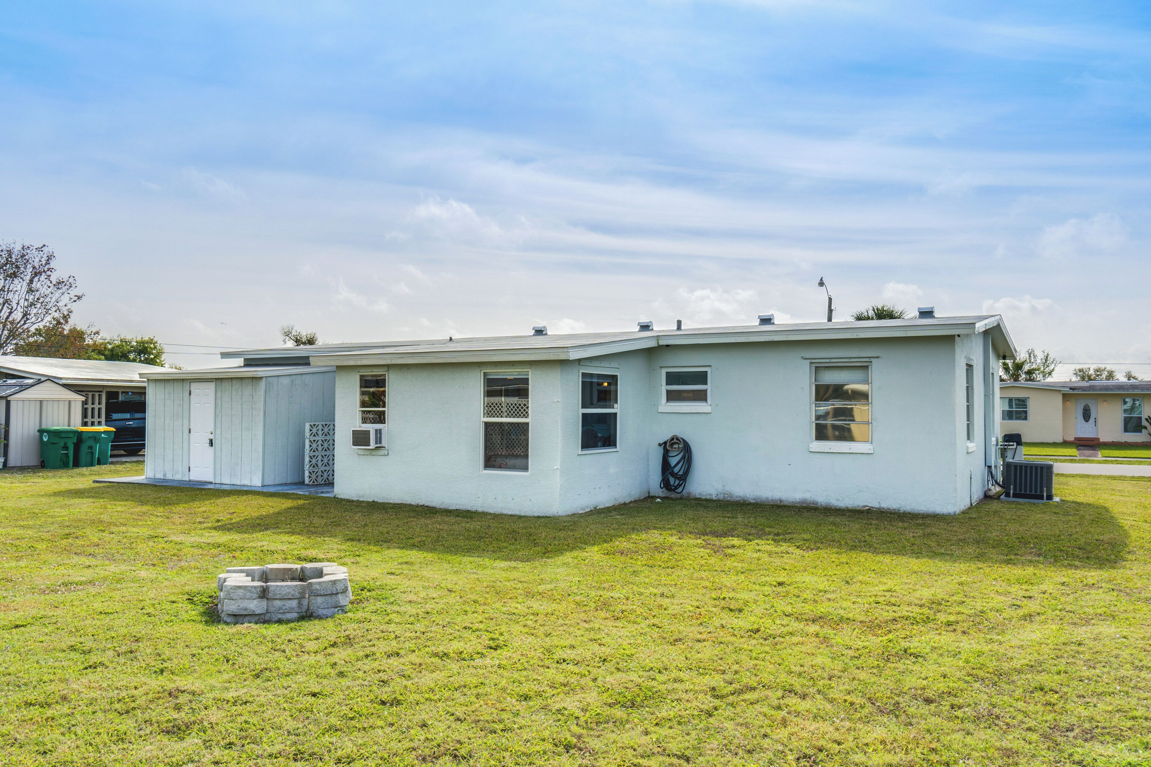 A single-story house with a flat roof, a front porch, and a small front yard.