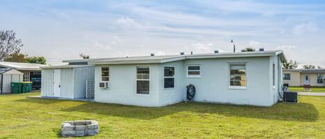 A single-story house with a flat roof, a front porch, and a small front yard.