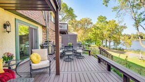 A deck with outdoor furniture, a grill, and a view of a lake. - Riverfront Champlin Townhome w/ Deck & Water View! (Champlin)