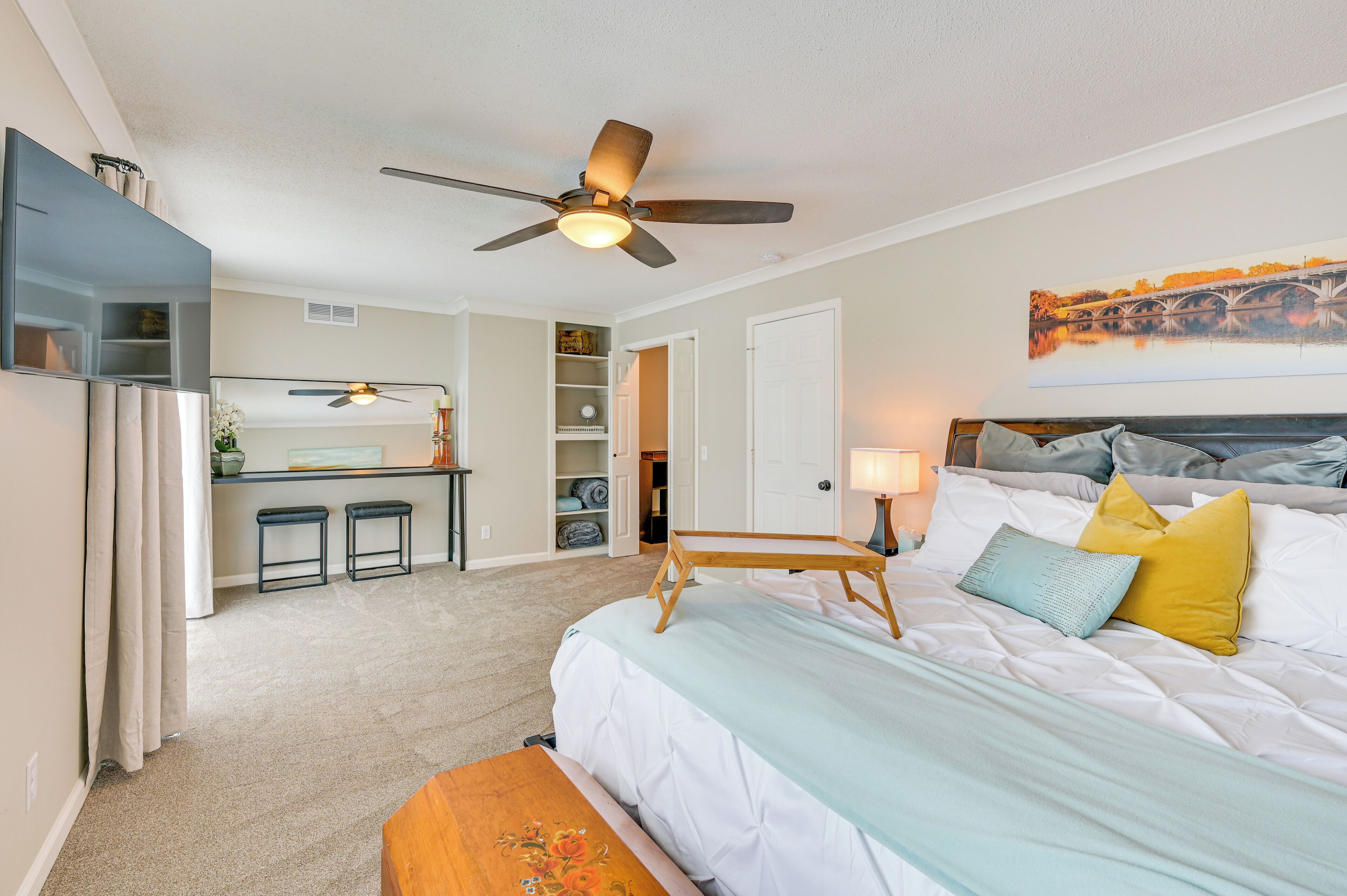 A bedroom with a bed, bedside table, and a ceiling fan.