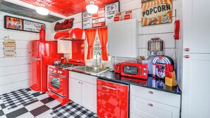 A retro-themed kitchen with red appliances, a checkered floor, and vintage decor. - Fifties Diner-style Llano Home w/ Shared Fire Pit (Llano)