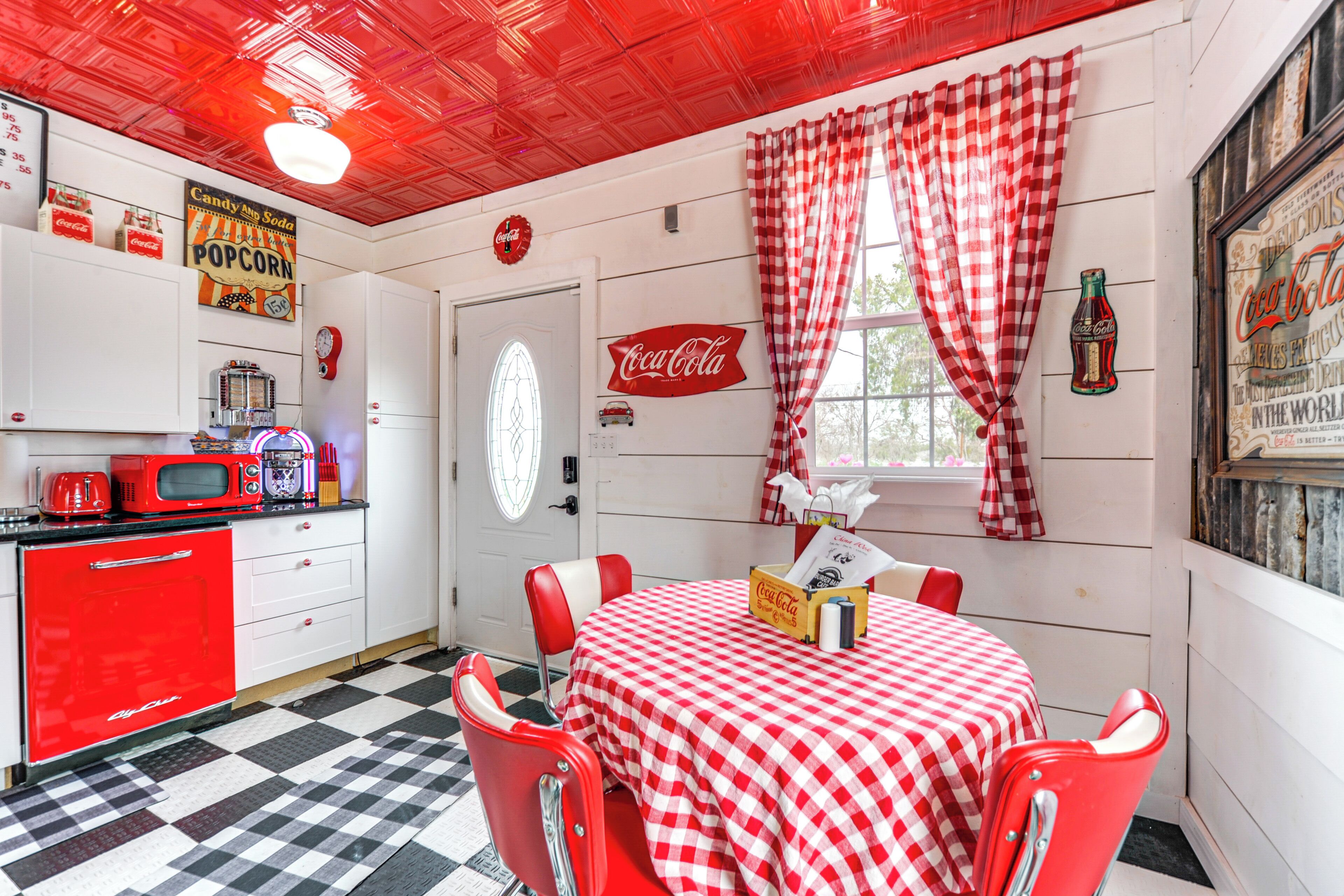 Eine Küche im Retro-Stil mit einem roten Kühlschrank, einer Mikrowelle und einer Popcornmaschine.