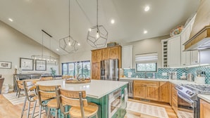 A spacious kitchen with a central island, wooden cabinets, stainless steel appliances, and pendant lighting. - Spacious Ruidoso Home: Hike, Golf, Ski & More! (Ruidoso)