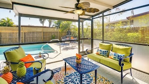 A covered outdoor area with a pool, seating, and a ceiling fan. - Port Charlotte Vacation Rental w/ Heated Pool! (Port Charlotte)