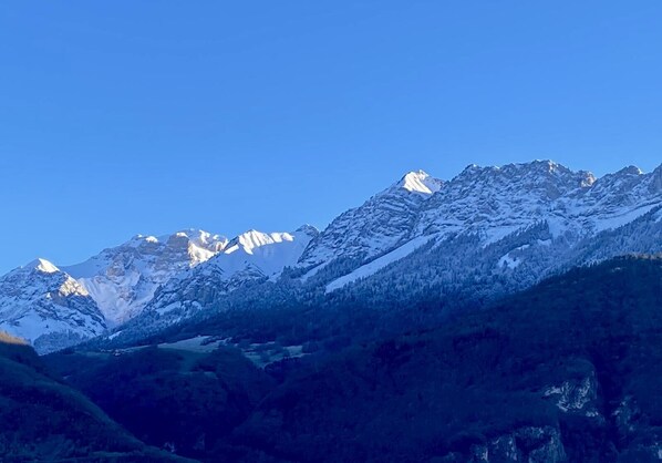 A mountain range with snow-covered peaks and a clear blue sky.