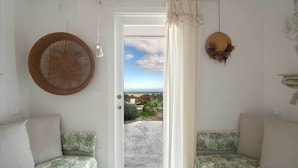 Una habitación con dos camas, una puerta que da a un balcón y vistas al exterior.