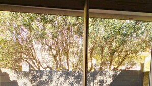 Eine Terrasse mit Holzdeck, einem weißen Tisch und einem Metallstuhl.