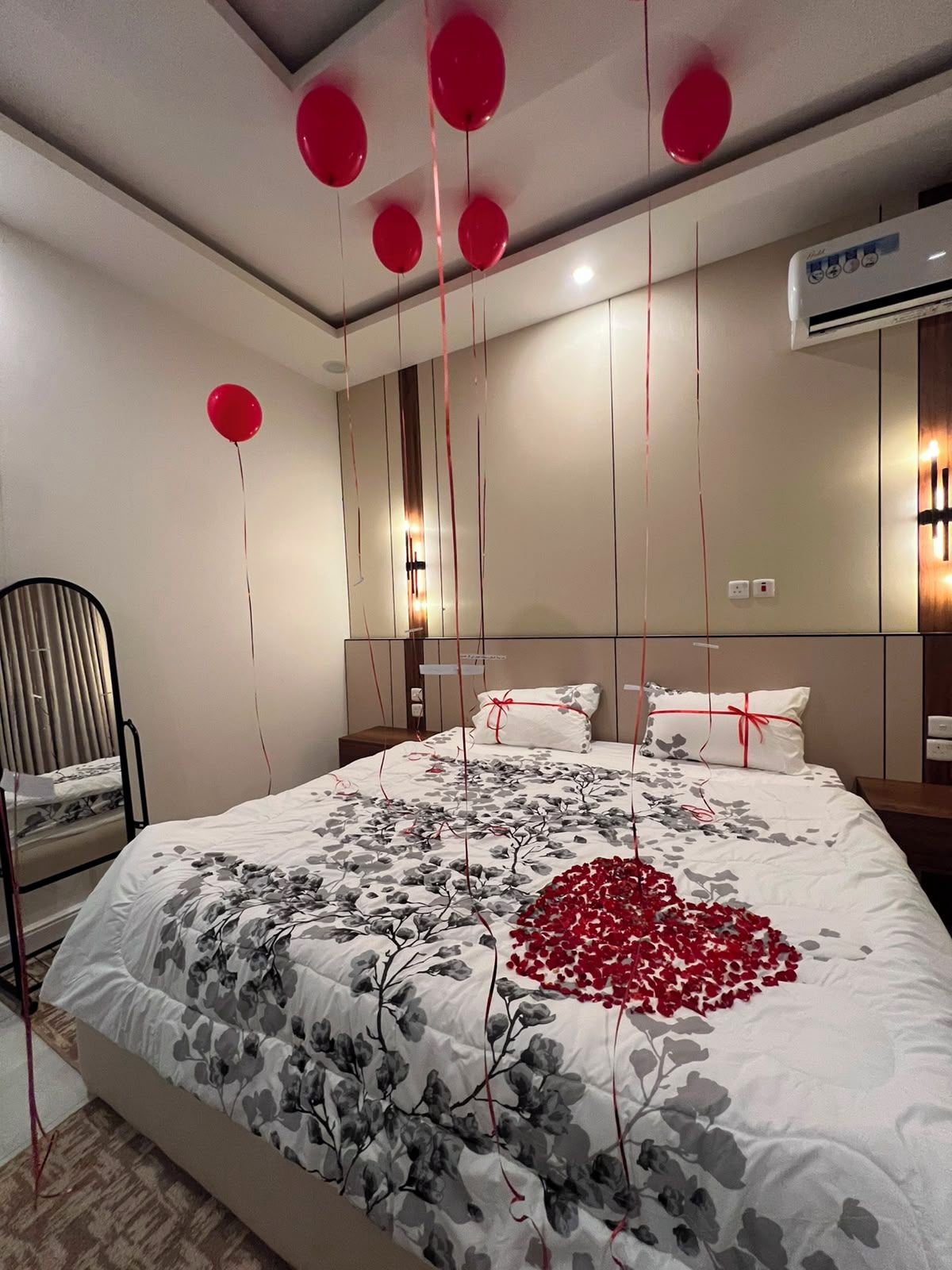 Un dormitorio con cama, una silla y un equipo de aire acondicionado.