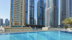 Una piscina con vista a edificios altos al fondo.