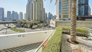 Una zona urbana moderna con edificios altos, una pasarela peatonal y palmeras.