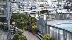 A marina with boats docked, a pool, and a garden with potted plants.