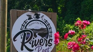 Un cartel que dice 'Rivers Rest', con un n úmero de reserva y un logotipo con un oso y un alce.