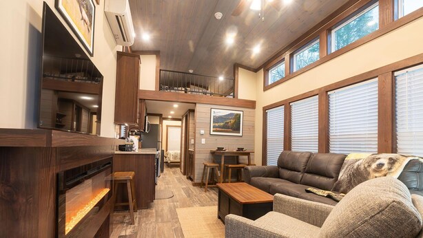 A cozy living room with a fireplace, a sofa, and a dining area with a table and chairs.