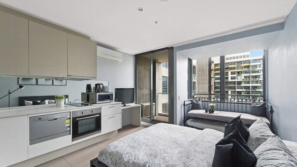 A modern apartment with a kitchen, a dining area, and a balcony with a city view.