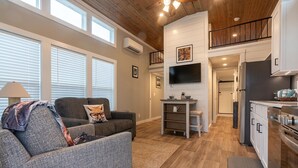 A modern living room with a grey sofa, a small table, and a TV.