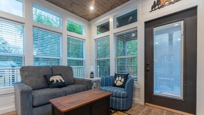 Una sala de estar acogedora con un sofá gris, un sillón azul y una mesa de centro de madera.