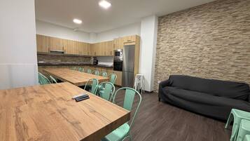 Een moderne keuken met houten kastjes, een centraal eiland en een eethoek met groene stoelen.