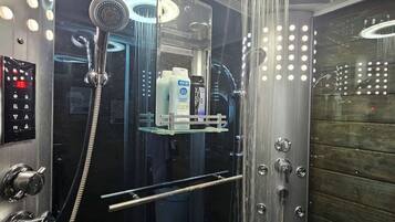 Une douche moderne dotée d’un panneau de commande, d’un espace clos en verre et d’un mur en bois.