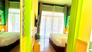 Ein Zimmer mit zwei Betten, Holzboden, einem grünen Bogen und einem Fenster mit Vorhängen.