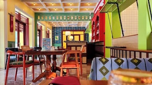 Ein Restaurant mit Holzbalkendecke, grünen Wänden und einer Essecke mit Holztischen und -stühlen.