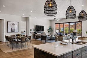 A modern kitchen with a large island, dining area with chairs, and a living room with a sofa and TV. - Bunker on the 8th: Private Pool, Pool Basketball, 2 sets washers and dryers (Washington)