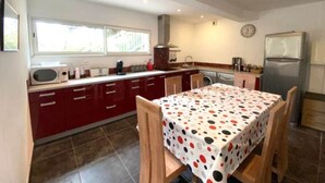 A compact kitchen with a dining area, featuring a microwave, stove, sink, and a refrigerator. - Appartement T3 - 50M DE LA Plage - Rupione (PIETROSELLA)