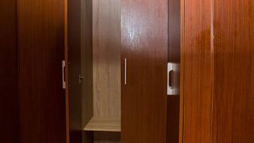 Een houten garderobe met verschillende vakken en een hangstang.