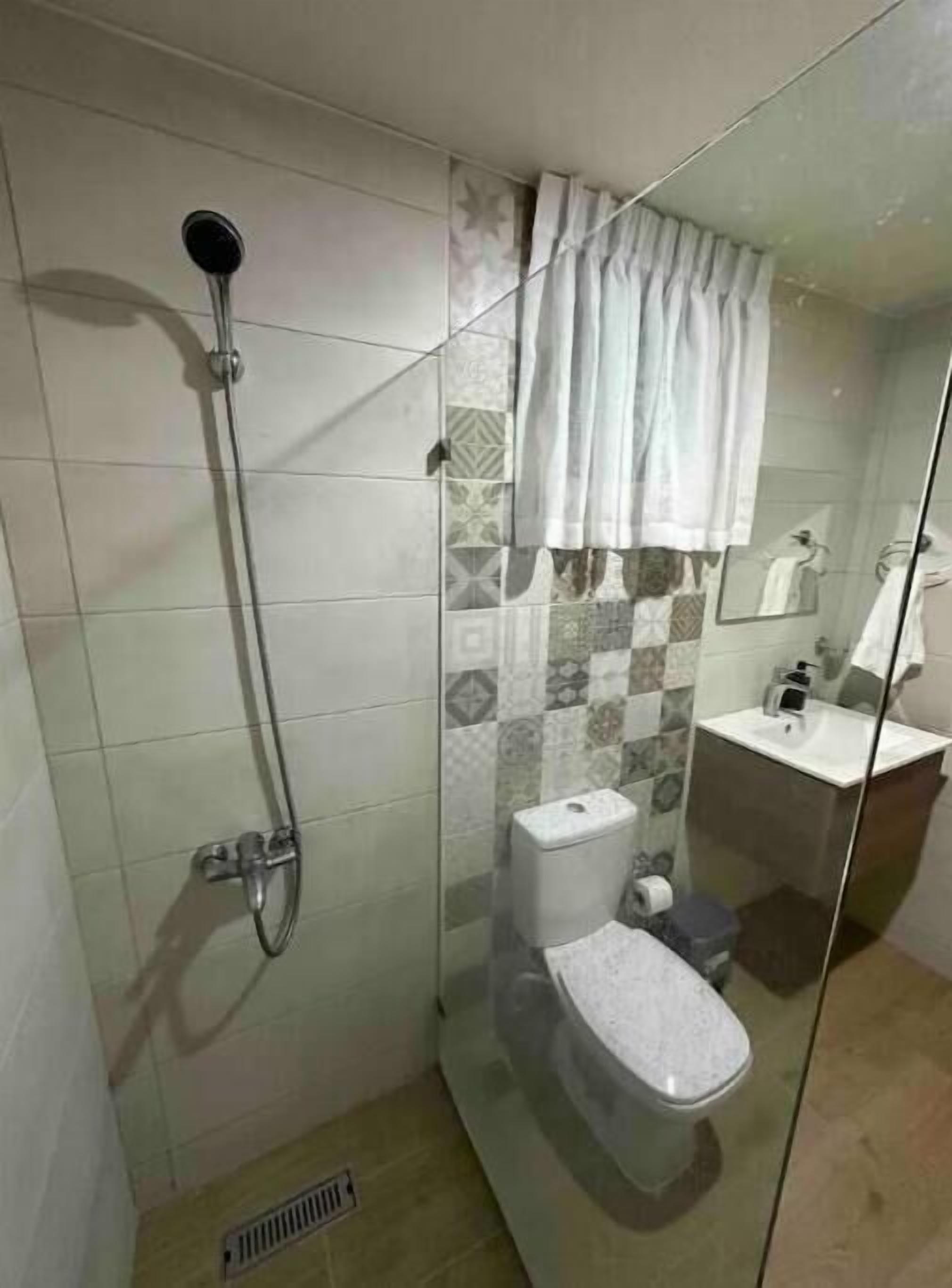 Un bagno con doccia, WC e lavabo.