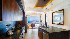 Una cocina moderna con una isla central, horno empotrado y un amplio ventanal con vistas al exterior.