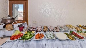 Ett buffébord med olika sorters mat och en kastrull på vänster sida.