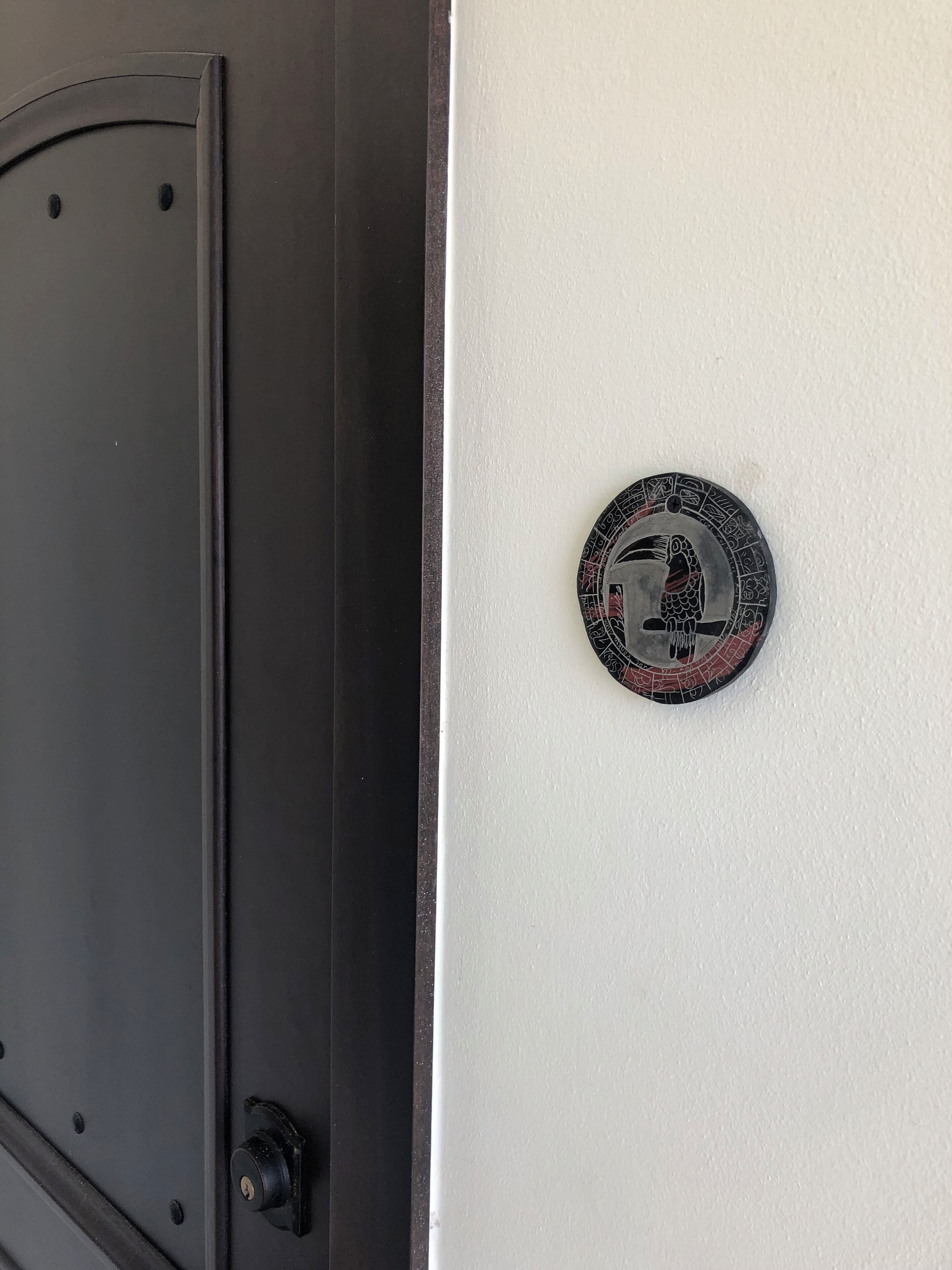 A door with a circular lock plate featuring a bird design.