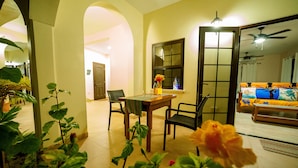 Un coin repas avec une table et des chaises, une fenêtre donnant sur un paysage agréable et un ventilateur de plafond.