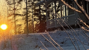 Un paysage enneigé avec une cabane en bois et un ciel dégagé.