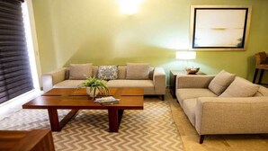 A living room with a sofa set, a coffee table, and a lamp.