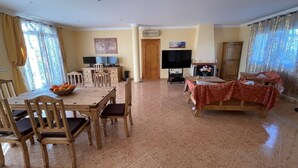 A spacious living area with a dining table, chairs, a sofa, and a television. - Casa Sabine, beautiful, modern, rural villa with 10m x 5m private pool (Zurgena)