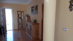 A spacious hallway with a wooden cabinet, a painting, and a door leading to another room. - Casa Sabine, beautiful, modern, rural villa with 10m x 5m private pool (Zurgena)