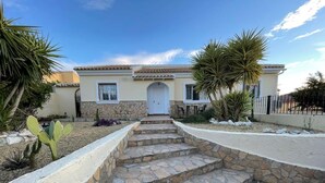 A house with a stone staircase leading to a white door, surrounded by cacti and a stone wall. - Casa Sabine, beautiful, modern, rural villa with 10m x 5m private pool (Zurgena)