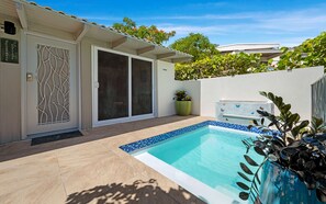 A residential property with a swimming pool, a sliding glass door, and a tiled patio area. - Seabreeze Cottage with private  pool and sunset view (Cruz Bay)