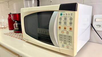 Um forno de micro-ondas branco com painel de controle e diversas funções de cozimento e um temporizador.