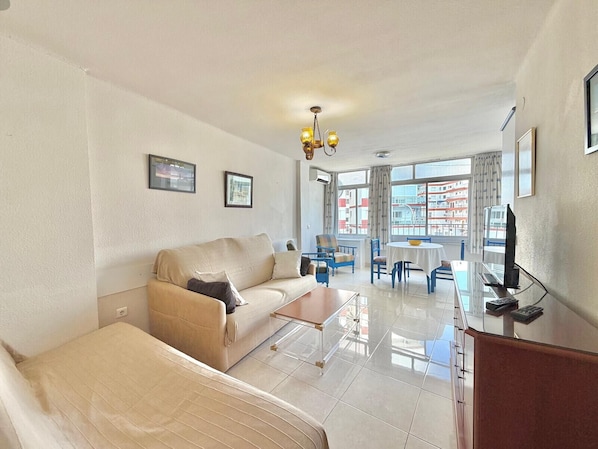 Una sala de estar moderna con un sofá, una mesa de centro y un comedor con sillas y una mesa.