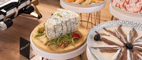 A buffet with various food items including cheese, salmon, and other dishes.
