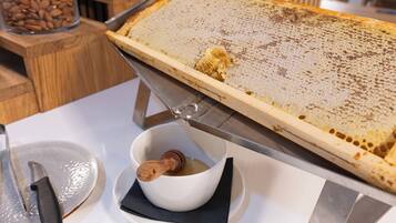 Ein Bienenwabenrahmen auf einem Tisch zusammen mit einem Messer und einer Honigschale.