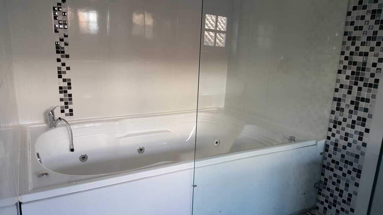 A bathroom with a bathtub, a shower, and a glass-enclosed shower area.