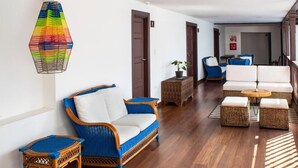 Una sala de estar moderna con un sofá, sillas y una lámpara colgante.
