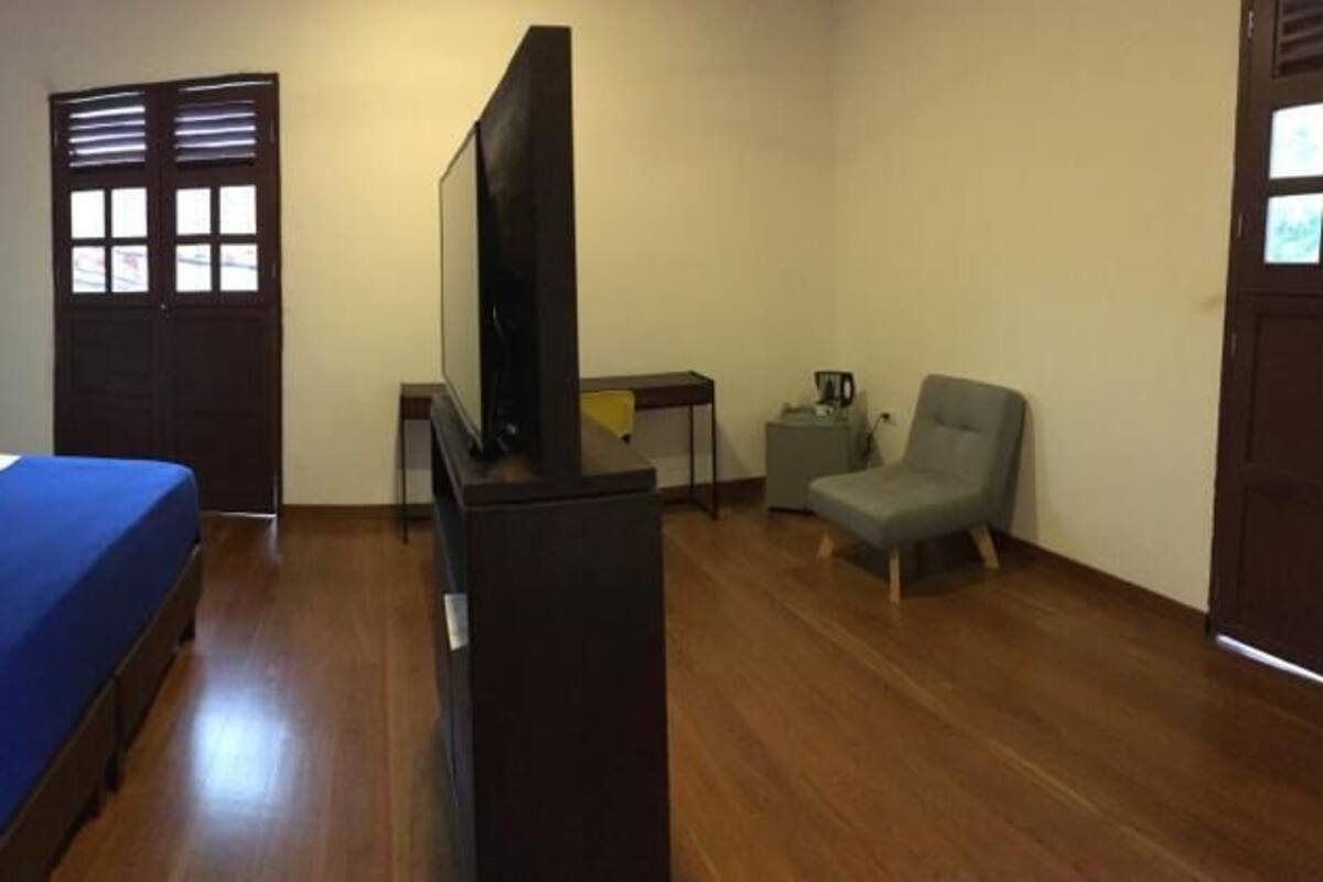 A hotel room with a bed, a television, a desk, and a chair.