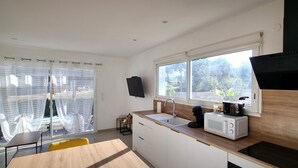 A compact kitchen with a microwave, coffee maker, and a large window. - L'eden des Aspres (Thuir)
